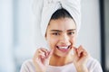 Oral hygiene is vital. Portrait of a beautiful young woman flossing her teeth in the bathroom at home. Royalty Free Stock Photo