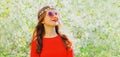 Portrait of beautiful young woman and flowers wearing floral headband, sunglasses on spring blooming garden background Royalty Free Stock Photo