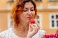 Portrait of the beautiful young woman with fresh red strawberries. Girl enjoy eating appetizing and juicy strawberry. Healthy food Royalty Free Stock Photo