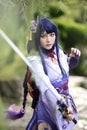 Portrait of a beautiful young woman game cosplay with samurai dress costume on Japanese garden Royalty Free Stock Photo