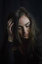 Portrait of a beautiful young woman with a hand on her head in her hair as she looks down thoughtfully Royalty Free Stock Photo