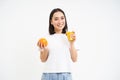 Portrait of beautiful young woman with healthy fit diet, drinks juice from fresh squeezed orange fruit, white background Royalty Free Stock Photo