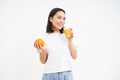 Portrait of beautiful young woman with healthy fit diet, drinks juice from fresh squeezed orange fruit, white background Royalty Free Stock Photo