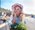 Portrait of a beautiful young woman, hippie style, enjoying bicycle outdoor under the sunlight. Palm trees and cactus around her. Royalty Free Stock Photo