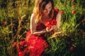 portrait of a beautiful young woman holding bouquet of red poppies. Royalty Free Stock Photo