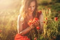 portrait of a beautiful young woman holding bouquet of red poppies. Royalty Free Stock Photo