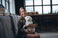 Portrait of beautiful young woman holding her dog in hands. Cute white dog in arms of loving owner. With dog in coffe