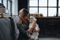 Portrait of beautiful young woman holding her dog in hands. Cute white dog in arms of loving owner. With dog in coffe