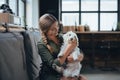 Portrait of beautiful young woman holding her dog in hands. Cute white dog in arms of loving owner. With dog in coffe