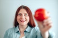 Portrait of a cheerful young woman eating red apple on gray wall background. Healthy nutrition diet. Apple vitamin snack Royalty Free Stock Photo