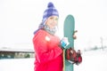 Portrait of beautiful young woman holding snowboard in snow Royalty Free Stock Photo