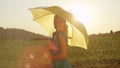 PORTRAIT: Beautiful young woman holding a yellow umbrella smiles into the camera Royalty Free Stock Photo