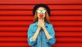 Portrait of beautiful young woman with lollipop blowing her lips with lipstick sending sweet air kiss wearing sunglasses, black Royalty Free Stock Photo
