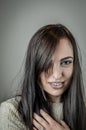 Portrait of a beautiful young woman with long brown hair with her hand on her chest looking intently Royalty Free Stock Photo