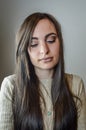 Portrait of a beautiful young woman with long brown hair a little sad looking down Royalty Free Stock Photo