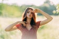 Portrait of beautiful young woman in with long brown hair in red pattern dress posing outdoors, dreaming, sensual, blurry smoky