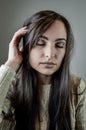 Portrait of a beautiful young woman with long brown hair who has a headache with her eyes closed Royalty Free Stock Photo