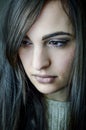 Portrait of a beautiful young woman with long brown hair who looks sad looking down Royalty Free Stock Photo