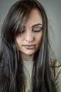 Portrait of a beautiful young woman with long brown hair who looks sad looking down Royalty Free Stock Photo