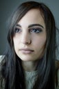 Portrait of a beautiful young woman with long brown hair who looks sadly lost in thought Royalty Free Stock Photo