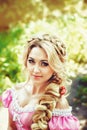 Portrait of a beautiful young woman with long hair braided in braid on the background nature. Royalty Free Stock Photo