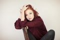 Portrait of a beautiful young woman with long red curly hair and perfect make up, cozy red winter sweater