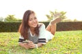 Portrait of beautiful young woman lying on green grass field and Royalty Free Stock Photo