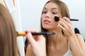 Beautiful young woman making make-up near mirror at home. Royalty Free Stock Photo