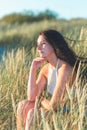 Portrait of a beautiful young woman on meadow watching the sunset enjoying nature summer evening outdoors Royalty Free Stock Photo