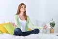 Portrait of beautiful young woman meditating on soft white bed Royalty Free Stock Photo