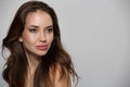 Portrait of beautiful young woman with natural skin make-up and brown hair on gray background Royalty Free Stock Photo