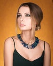 Portrait of beautiful young woman with a necklace on her neck. Hairstyle and make-up