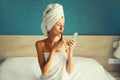 Portrait of beautiful young woman painting her lips with red lipstick applying makeup looking in pocket mirror and drying her wet Royalty Free Stock Photo