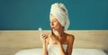 Portrait of beautiful young woman painting her lips with red lipstick applying makeup looking in pocket mirror and drying her wet Royalty Free Stock Photo