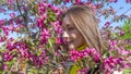 Portrait of beautiful young woman in paradise apple trees blooming park on a sunny day. Springtime. Red apple tree Royalty Free Stock Photo