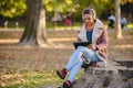 Portrait of beautiful young woman in the park using laptop computer listening over headphones studying outdoors in the nature Royalty Free Stock Photo