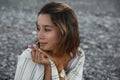 Portrait of beautiful young woman on pebble beach