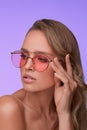 Portrait of beautiful young woman with perfect makeup wearing pink sunglasses. Royalty Free Stock Photo