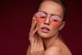 Portrait of beautiful young woman with perfect makeup wearing pink sunglasses. Royalty Free Stock Photo