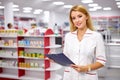 Portrait of beautiful young woman pharmacist at modern drugstore Royalty Free Stock Photo