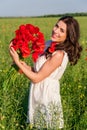 Portrait of beautiful young woman with poppies in the field with a poppies bouquet. Royalty Free Stock Photo