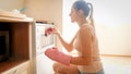 Portrait of beautiful young woman putting baking pan with cookies in the hot oven at kitchen Royalty Free Stock Photo