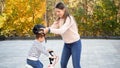 Portrait of beautiful young woman putting protective helmet on her son before teaching riding a bicycle Royalty Free Stock Photo