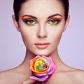 Portrait of beautiful young woman with rainbow rose