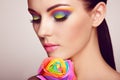 Portrait of beautiful young woman with rainbow rose