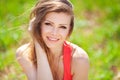 Portrait of a beautiful young woman in a red dress on a background of sky and grass in summer Royalty Free Stock Photo