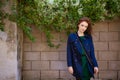 Beautiful young woman with red hair and freckles on background of wall Royalty Free Stock Photo