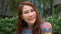 Portrait of a Beautiful Young Woman with Red Hair Wearing colorful Sweater in the garden and Looking Up to the Camera and Smiling Royalty Free Stock Photo