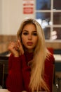 Portrait of a beautiful young woman in a red sweater at a cafe Royalty Free Stock Photo