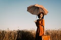 Woman with umbrella and suitcase on the field Royalty Free Stock Photo